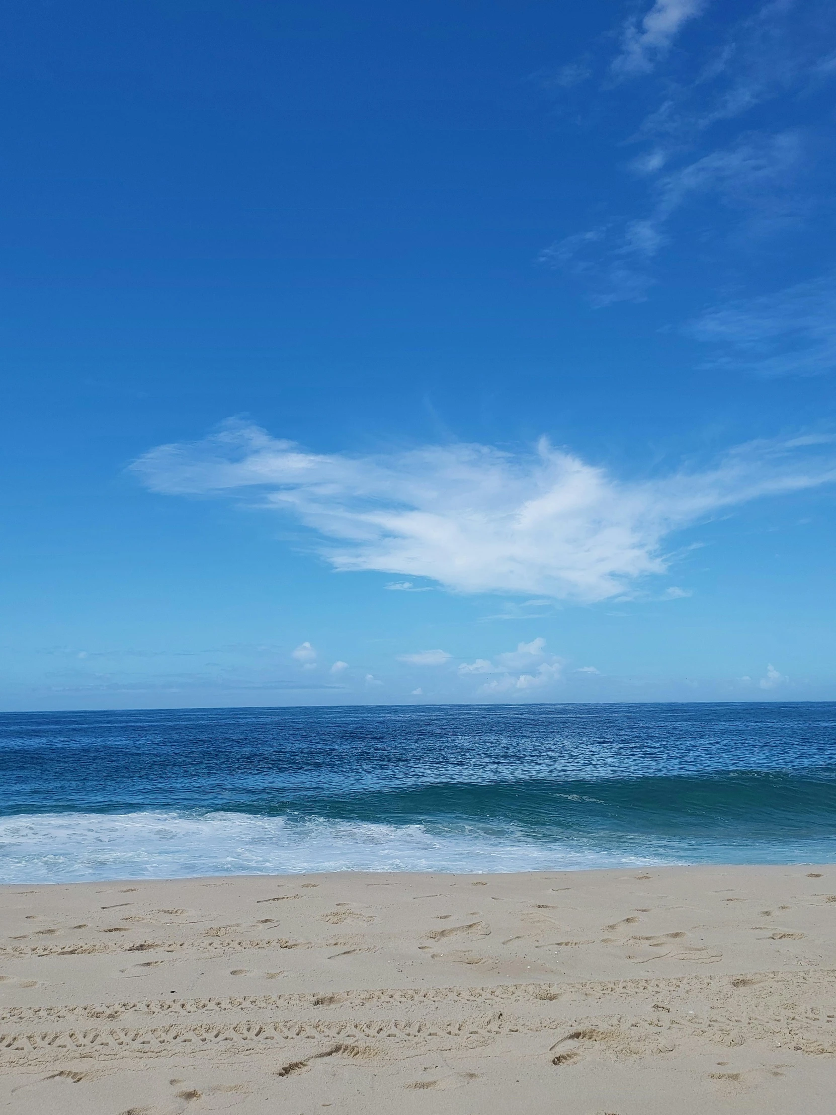 a boat is anchored on the beach as waves wash onto it