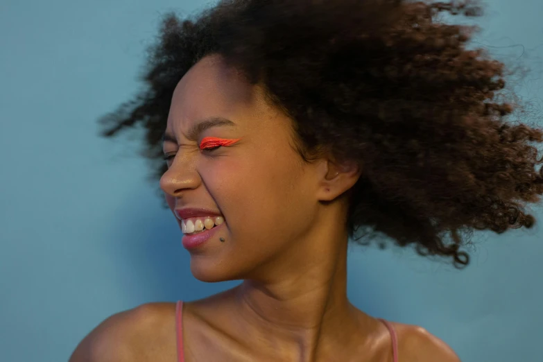 a close up of a person with an orange colored eyeliner