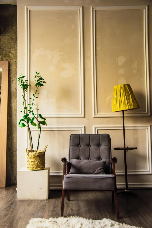 a chair sitting next to a lamp and plant