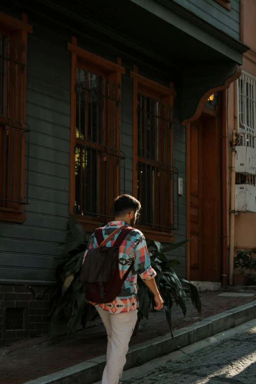 man in striped shirt walking down the street