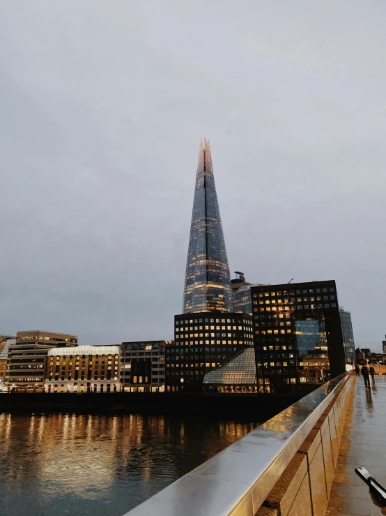 a building stands high above the water in the evening