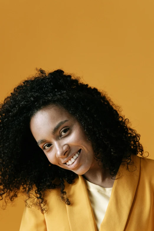 a woman with long curly hair posing for a po