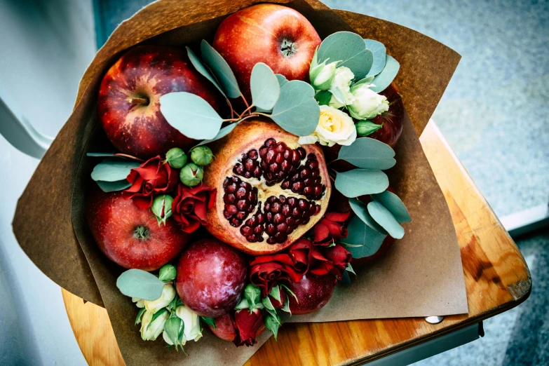 some pomegranates and flowers inside of a piece of cardboard