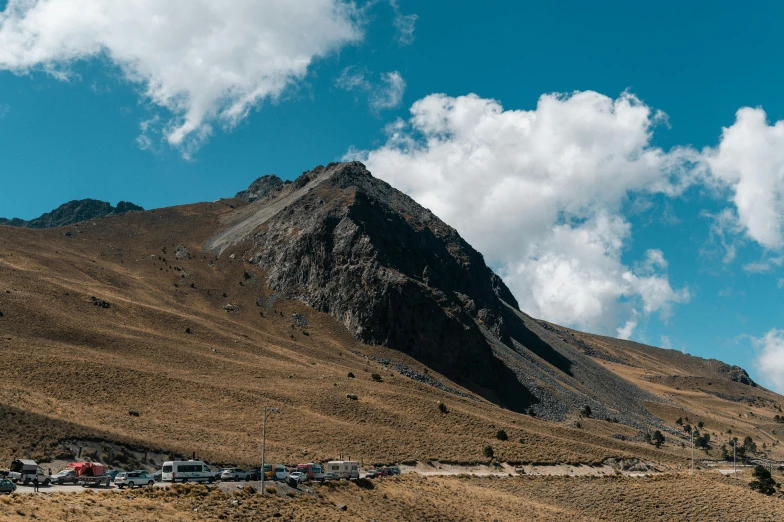 a large mountain with trees and buildings near by