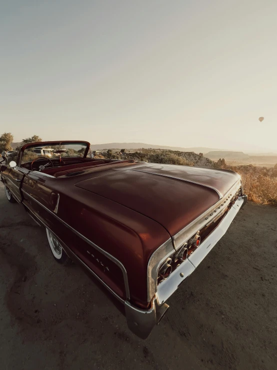 the old, classic car parked in the dirt