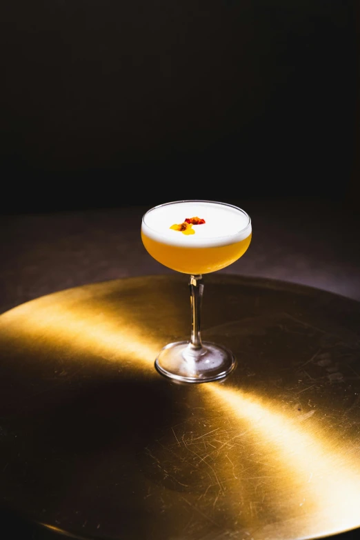 a golden wine glass sits on the top of a gold table