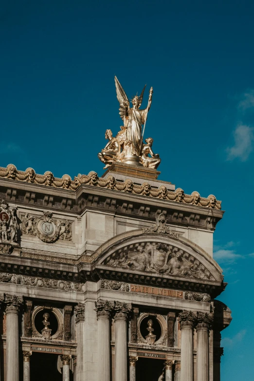 the side view of a large building that has a statue on top