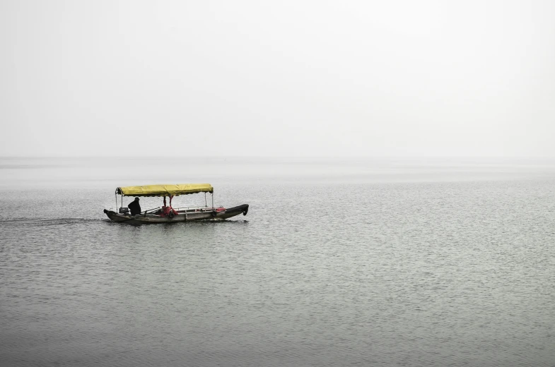 two people in the ocean with a small yellow boat