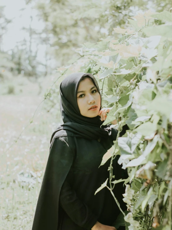 a woman in a black top is posing for the camera