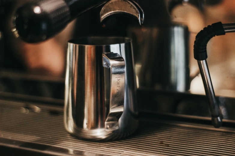 an espresso machine is filling a cup of coffee