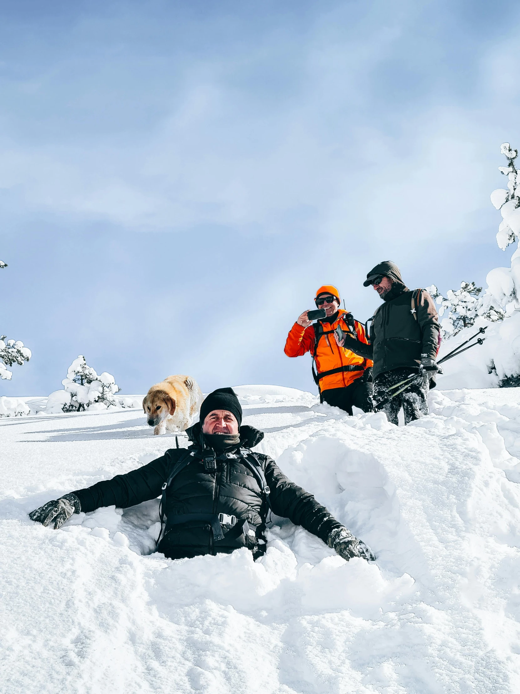 three people in winter clothes sitting in the snow