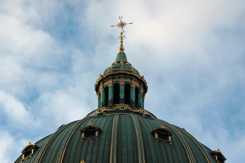 the top of a green building with a steeple