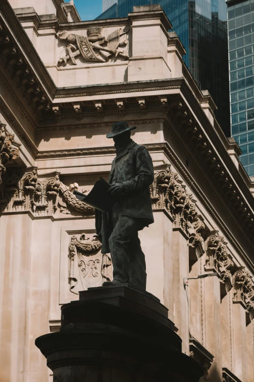 a close up of a statue near a tall building