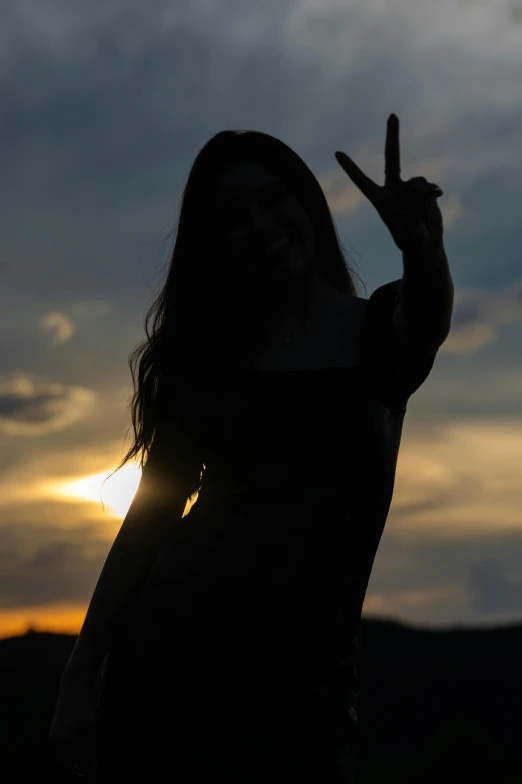 the woman poses for the camera while holding up her peace sign