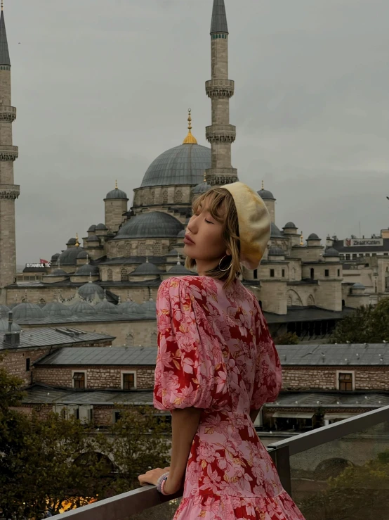 a woman wearing a hat and dress posing for a pograph