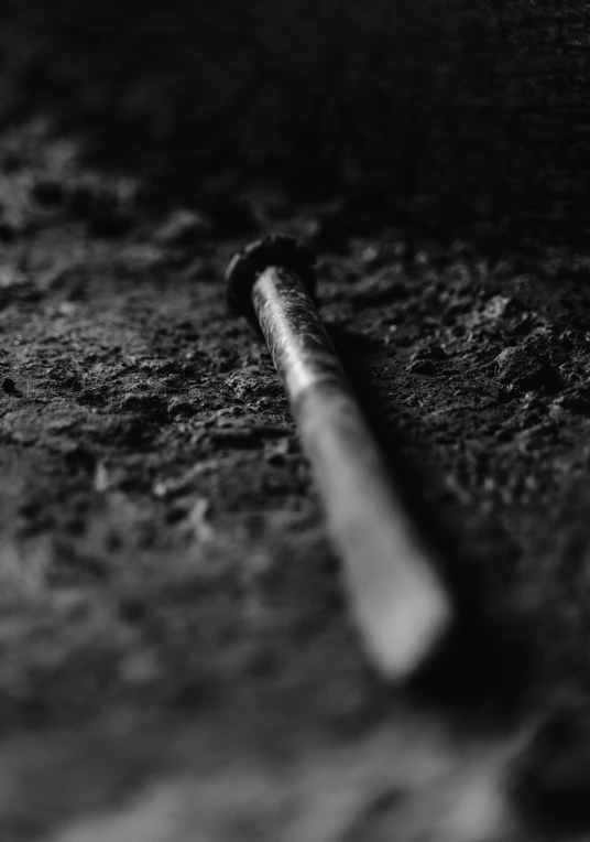 a closeup of a baseball bat with dirt on the ground