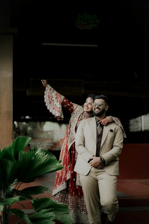 a couple posing for a po while dressed in colorful indian costumes