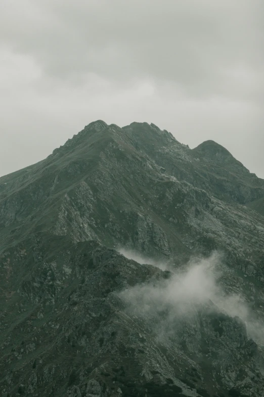 the mountains covered with white clouds are in the dark sky