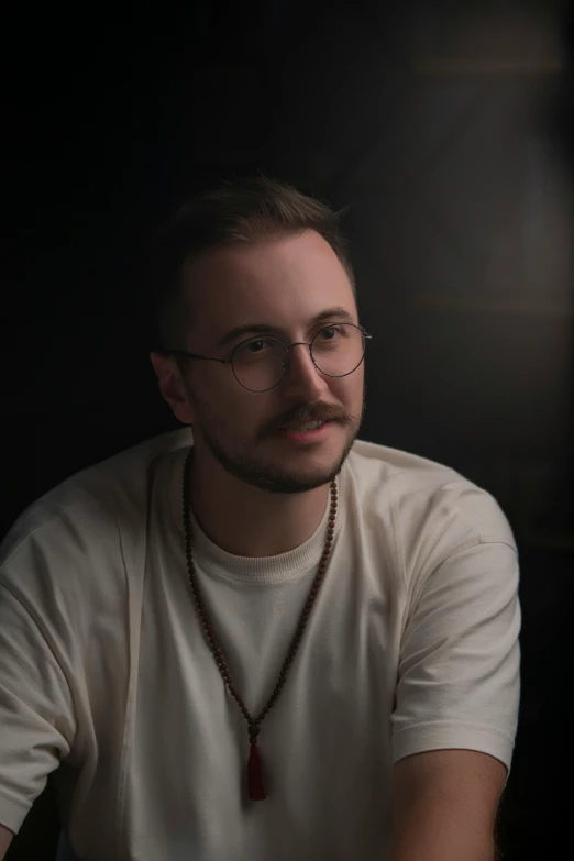 a man wearing glasses while sitting down