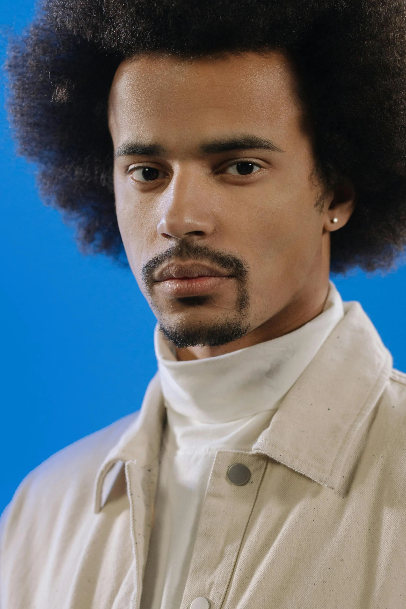 a close - up portrait of an afro man with a neutral shirt