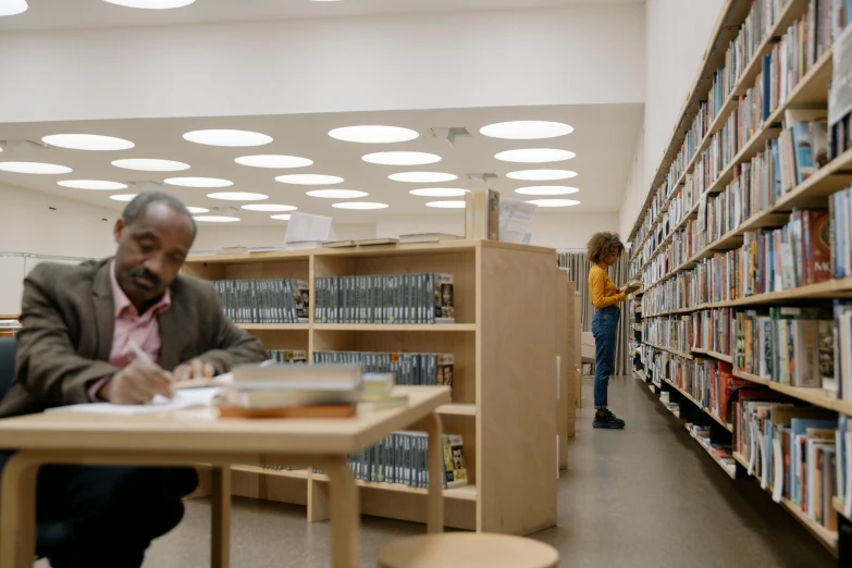 two people in a liry that have bookshelves