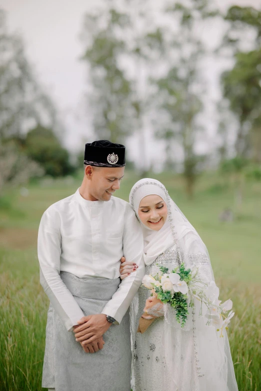 a married couple wearing traditional japanese clothing stand in a grassy field