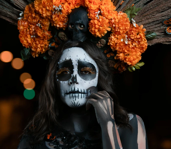 a girl with skull makeup is wearing flowers