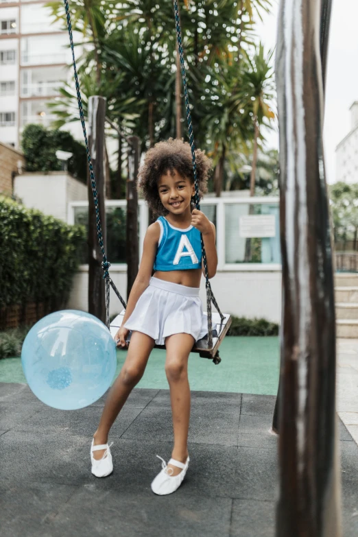 a girl is playing with a blue ball