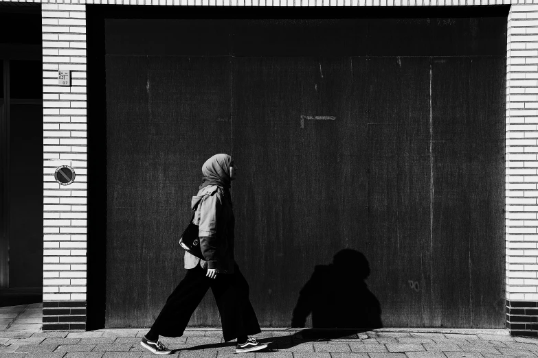 a man walking down the street with his skateboard