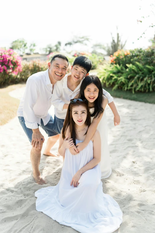 a man, two girls and an elderly man pose for a family po