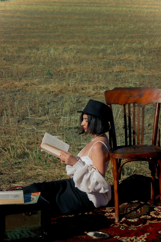 woman sitting on the ground and reading a book