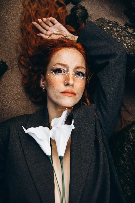 a woman with red hair and makeup poses