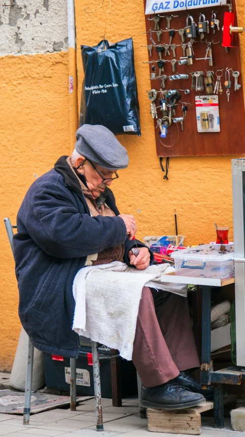 an elderly person sitting at a table with jewelry