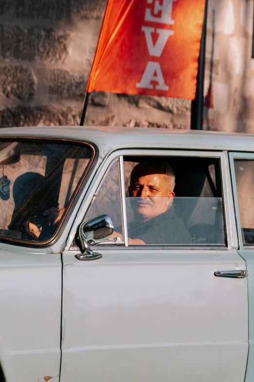 a man looking out the window of an old, run down car