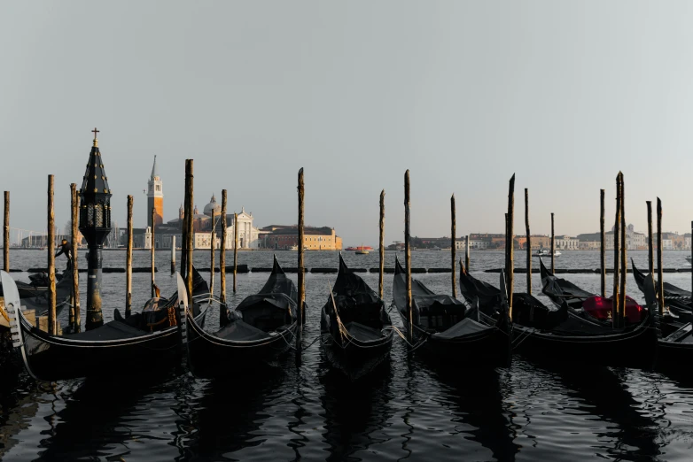 a bunch of gondoles are docked in some water