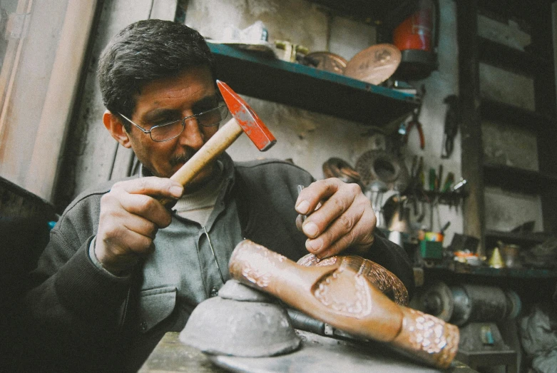 a man carving a loaf with an old handled mach