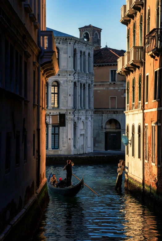 two people riding in small boats on a narrow canal