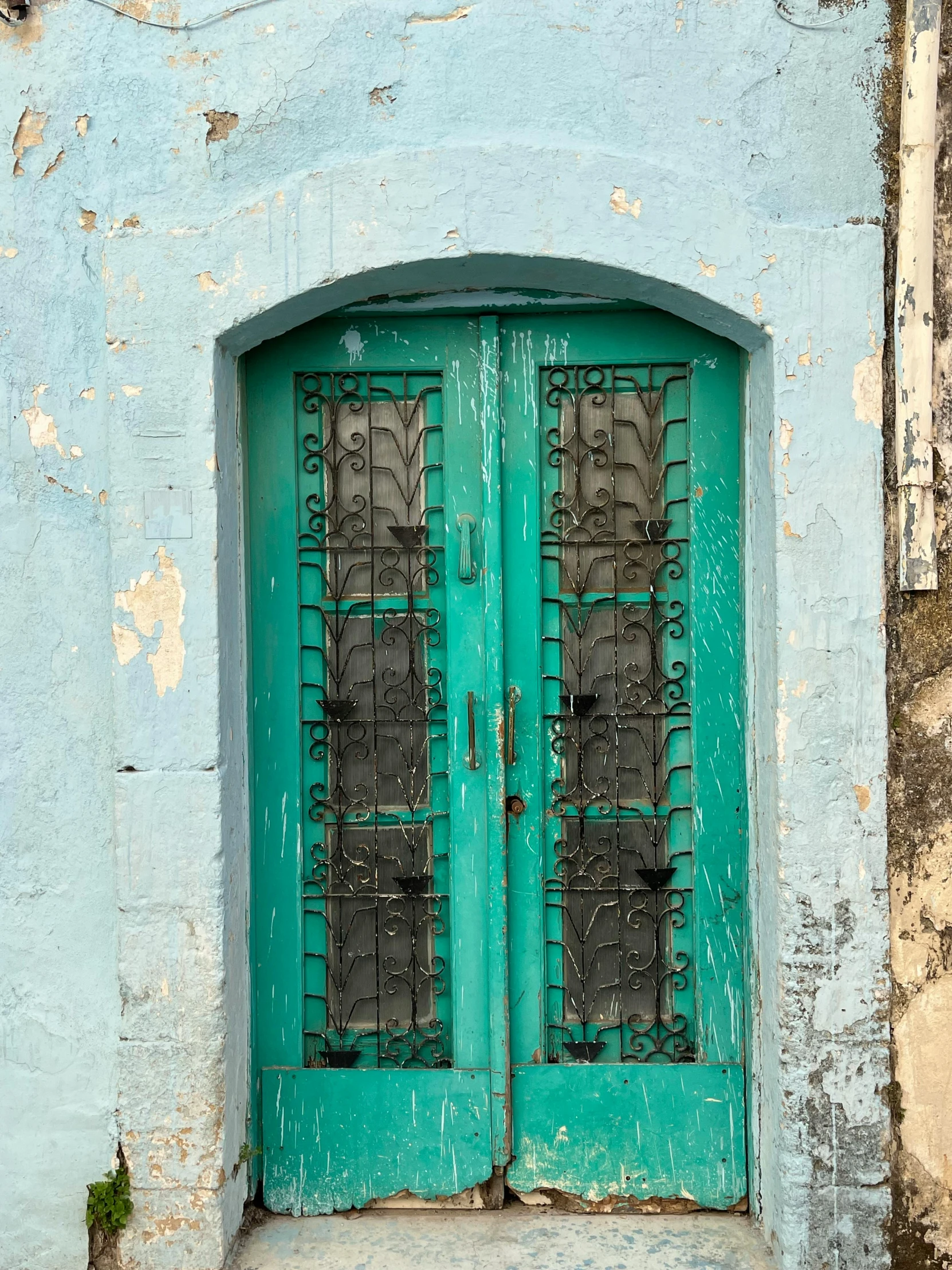 an open, green doorway between two buildings