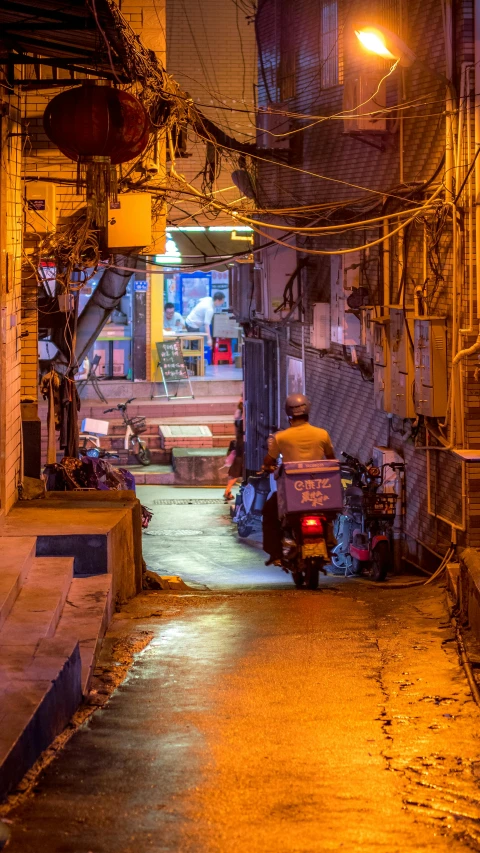 an alley filled with cars and people walking down it