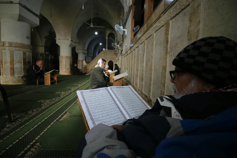 the inside of a mosque with a bunch of prayer books laying in front of them