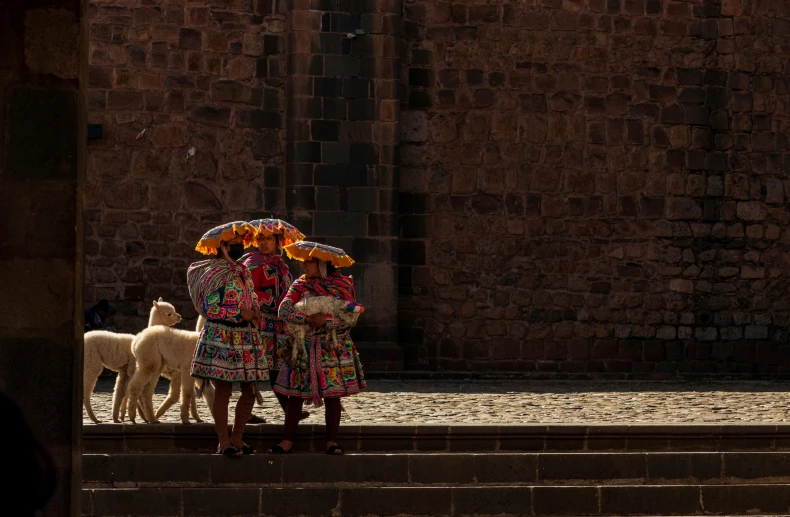 three women with umbrellas are walking down a sidewalk