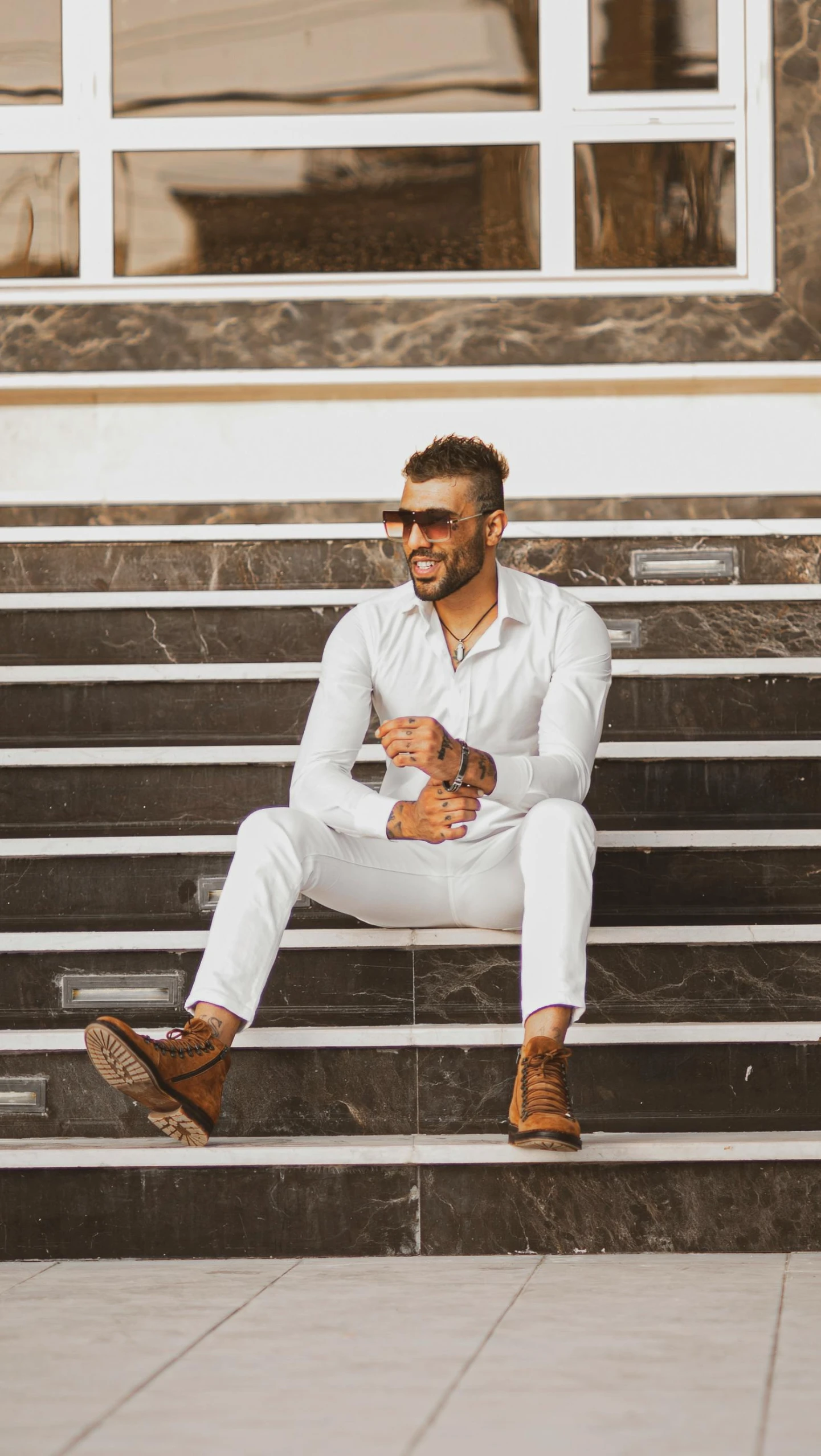 a man in a suit and tie sitting on a set of steps