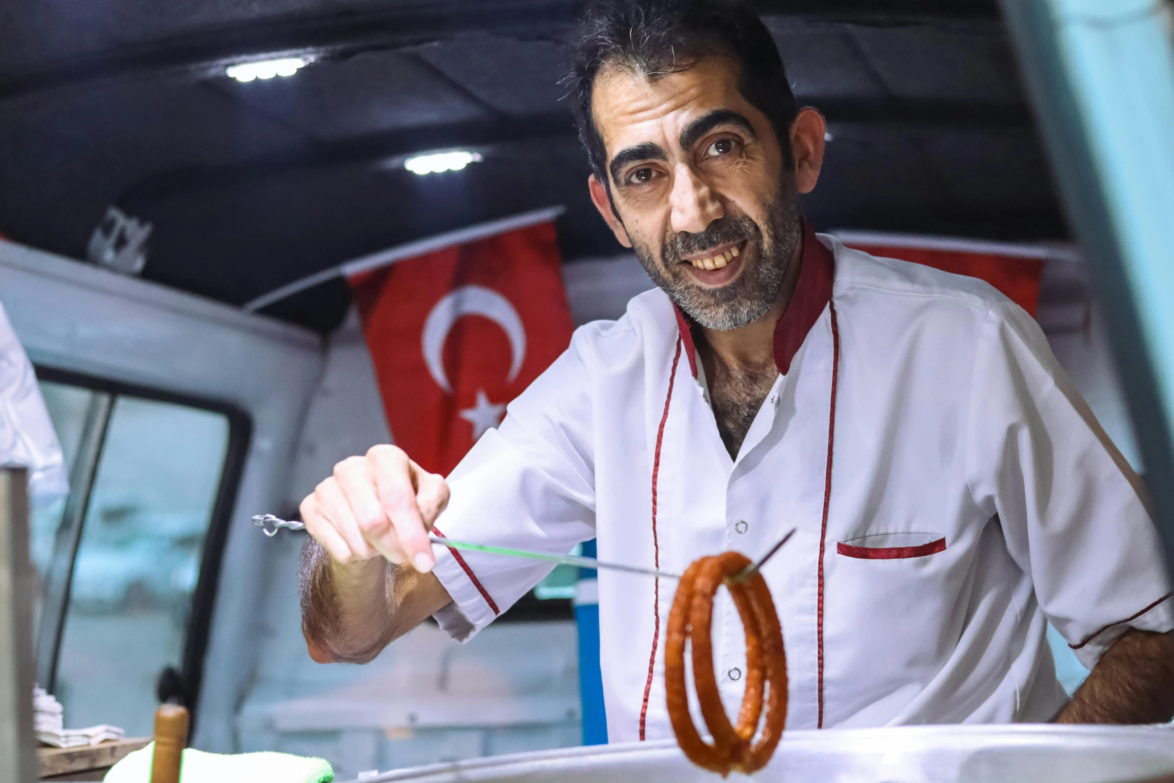 the man is stirring with a fork and sausage ring