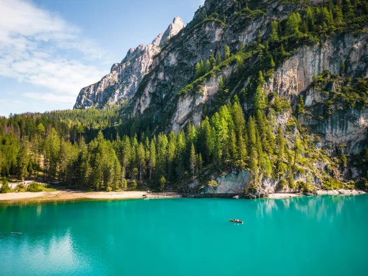 a lone boat is at the bottom of this lake in the mountains