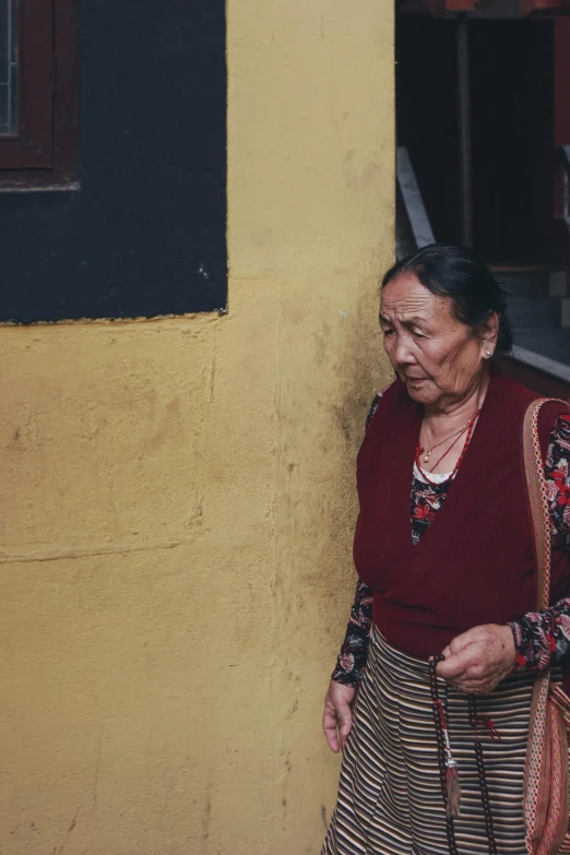 an older woman standing next to a building