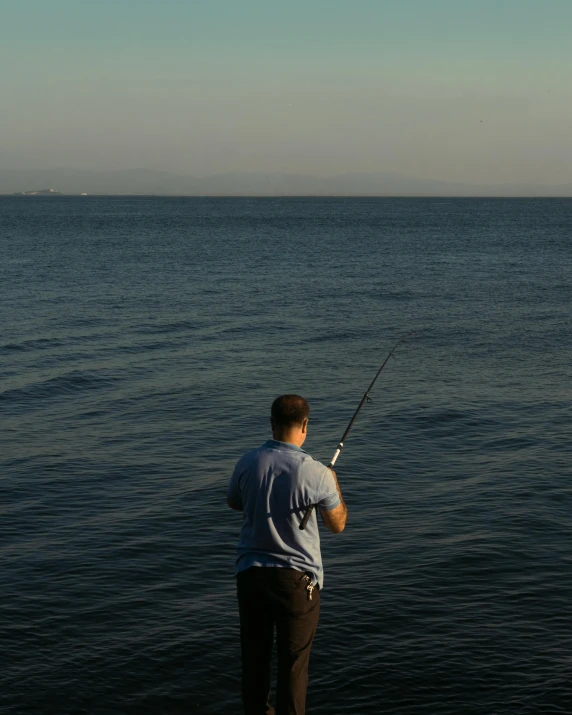 a man fishing on the lake with his rod