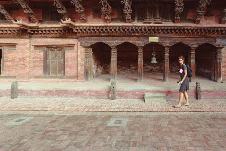 a woman walks down the street in front of a building