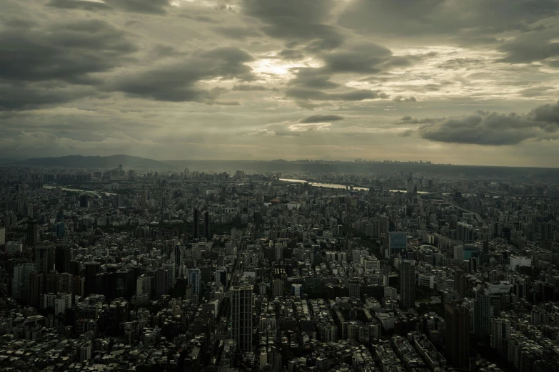 an aerial view of large city with cloudy sky