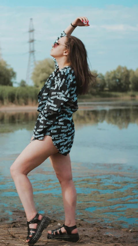 a woman standing on top of a lake next to a wooden bench