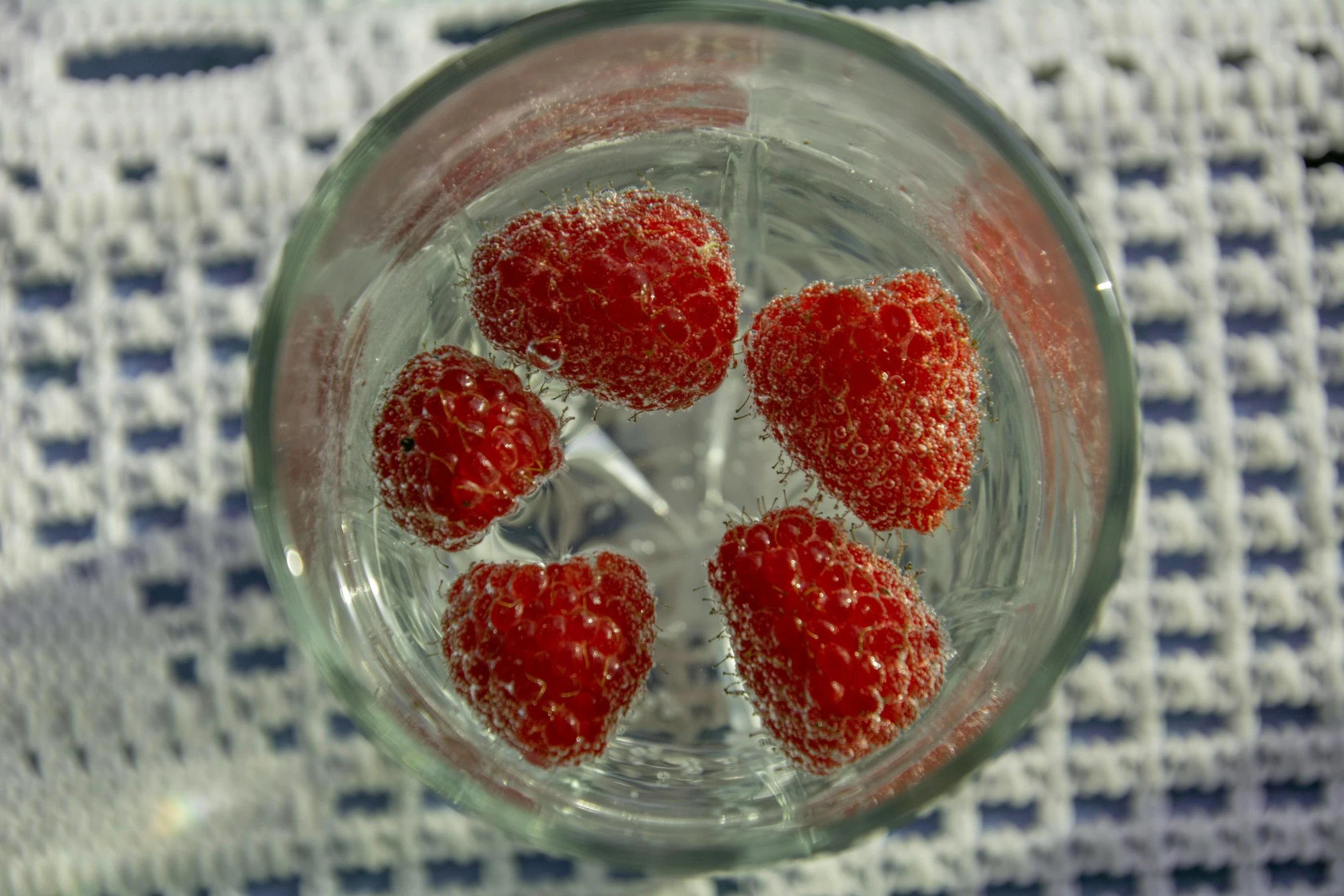 strawberries are inside a glass with water in it